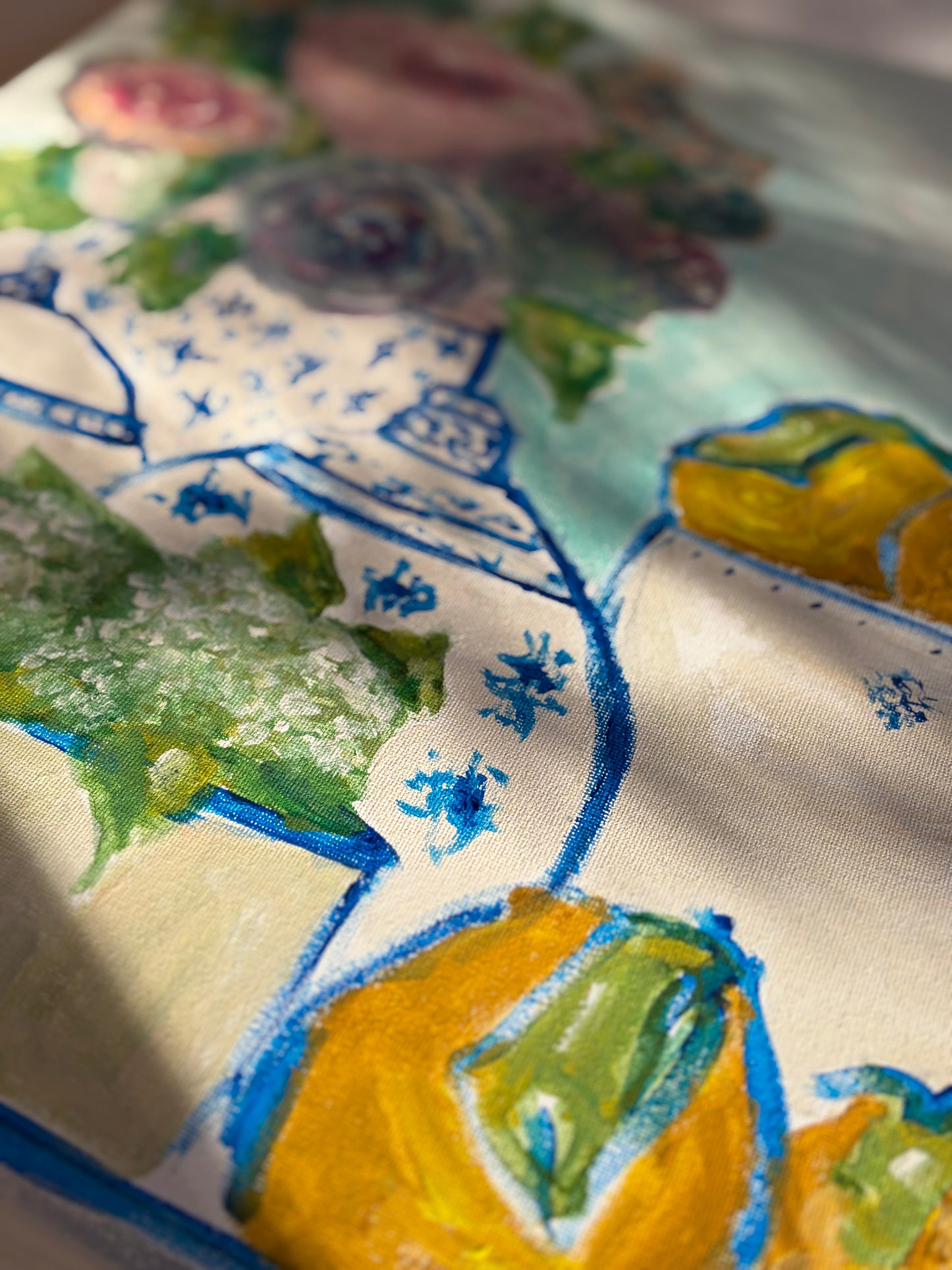 Detail of an original still life painting featuring blue and white porcelain, flowers, and lemons